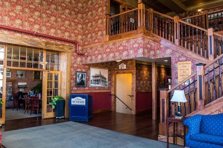 The lobby of the Weatherford Hotel, with its patterned red wallpaper and wooden staircase, where the tour meets.